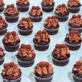 Chocolate Cupcakes with moist sponge, chocolate buttercream, ganache drizzle, and handmade truffles by Crumbs & Doilies.